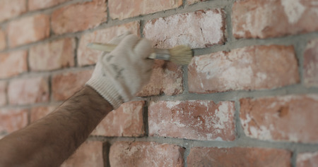 closeup of worker forming seam between bricksの写真素材
