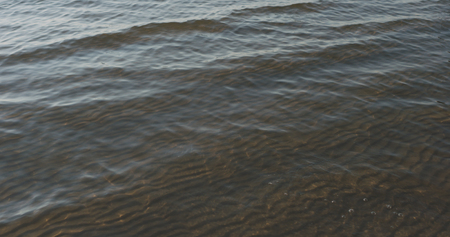 small waves on sandy sea beach on a sunny day, wide photo