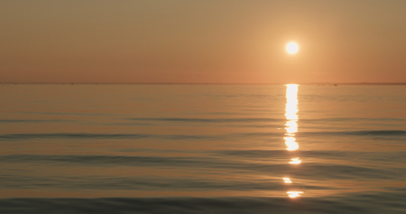 small waves on a beach at sunsetの写真素材