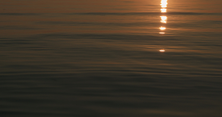 small waves on a beach at sunsetの写真素材