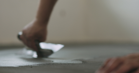 closeup worker applying micro concrete on the floor with a trowelの写真素材