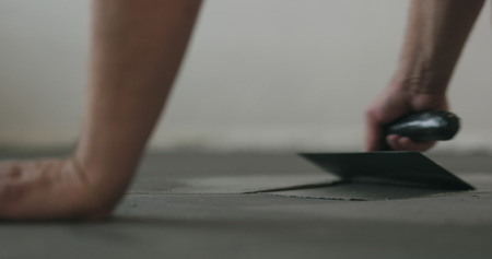 closeup worker applying micro concrete on the floor with a trowelの写真素材