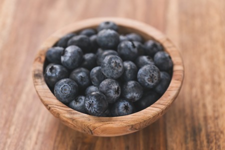 Fresh blueberries in wood bowl on table slightly tonedの写真素材