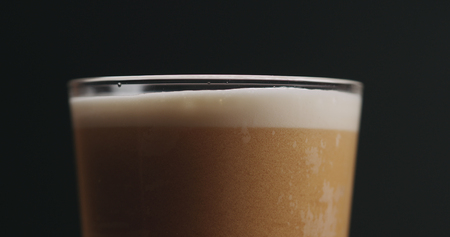 closeup ale beer in a glass over black backgroundの写真素材