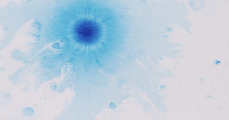 blue ink drops spreads on white wet paper, wide photo