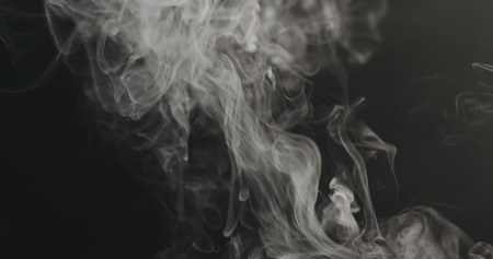 closeup vapor rises from bottom on black background, wide photoの写真素材