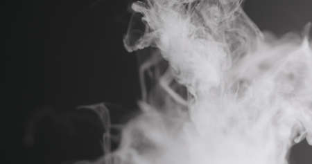Slow motion closeup vapor floating in air on black background