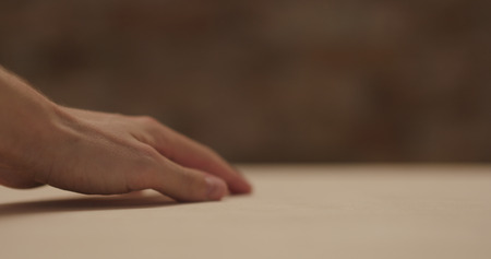 closeup man hand touches plywood to check surface