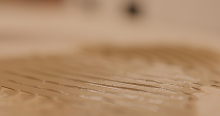 Closeup man applying polyurethane adhesive for parquetの写真素材