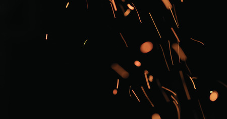 hot sparks from charcoal moving up on black background, wide photo