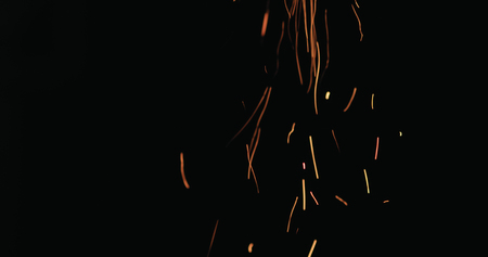 hot sparks from charcoal moving up on black background, wide photoの写真素材