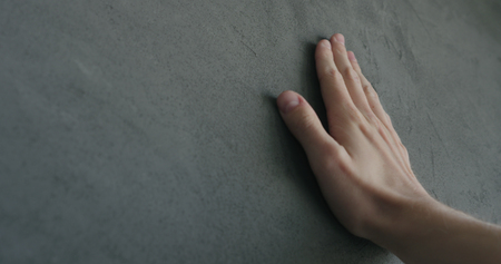 man hand touches decorative concrete finish, shallow focusの写真素材