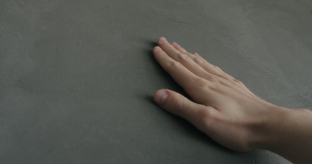 man hand touches decorative concrete finish, shallow focusの写真素材