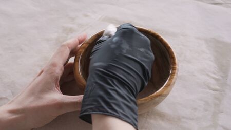 woodworker applying oil finish to olive wood bowl from above