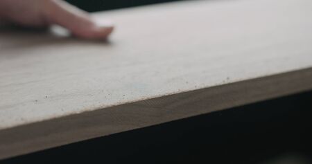 woodworker hand sanding walnut board with sand blockの写真素材