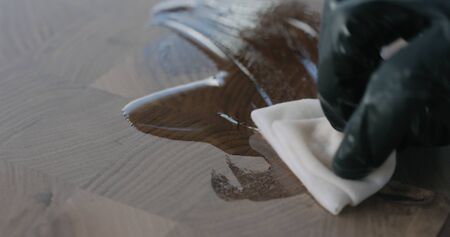 woodworker applying oil finish to walnut end grain wood board