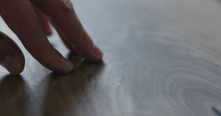 closeup man hand checking untrated black walnut solid board