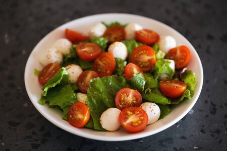 Salad with mozzarella balls tomatoes and mix saladの写真素材