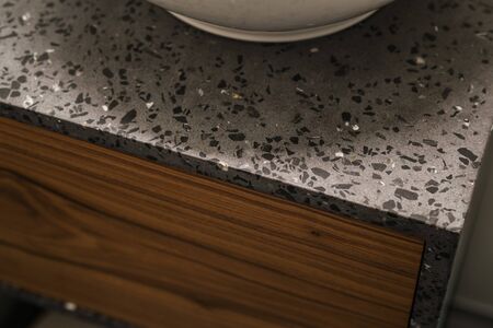 Closeup detail shot of gray terrazzo bathroom cabinet with black marbleの写真素材