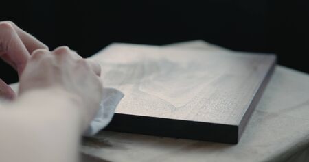woodworker applying oil finish to black walnut boardの写真素材