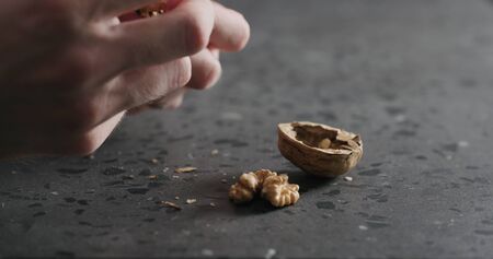 closeup man hands opens walnutの写真素材