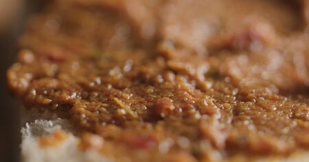 Extreme closeup of ciabatta slice with red pesto