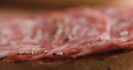 Extreme closeup laying salami slices on ciabatta, wide photoの写真素材