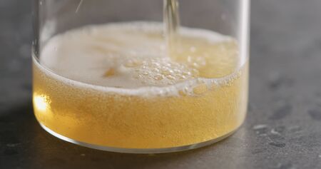 Closeup pour pear cider into glass on terrazzo countertopの写真素材