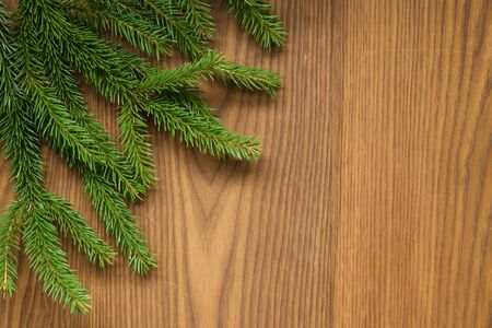 Flat lay christmas background with spruce twigs on ash wood surface, good for backdrop