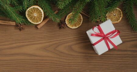Top view christmas composition with white gift box, spruce branches and natural decorations, wide photoの写真素材
