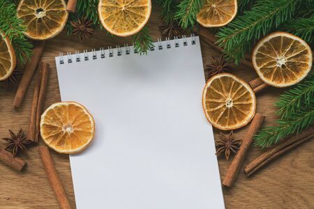 Flat lay empty notepad with spruce twigs and decorations on oak wood surface good for backdropの写真素材