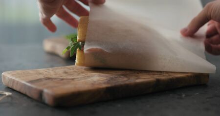 man hands packing ciabatta sandwich with salami and cheese