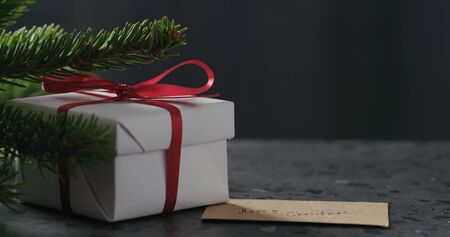 merry christmas paper card next to gift boxの写真素材
