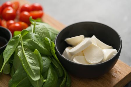 ingredients for salad, mozzarella, spinach and cherry tomatoes