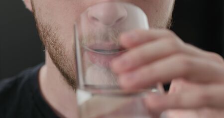 closeup shot of bearded man drinking water from glass, wide photoの写真素材