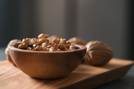 Walnuts in wooden bowl on olive board , shallow focusの写真素材