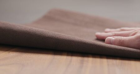 man hand checking brown leather piece closeup, wide photo