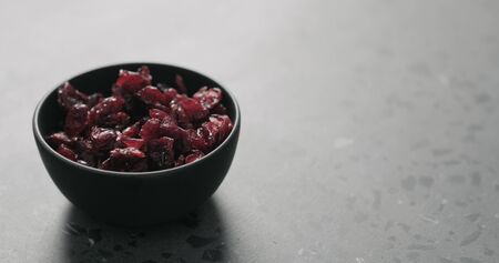dried cranberry in black bowl on terrazzo countertop, wide photoの写真素材