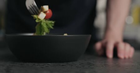 man tasting salad on terrazzo countertopの写真素材