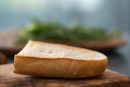 Toasted half of ciabatta for sandwich on olive board, shallow focusの写真素材