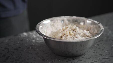 dough in steel bowl on concrete countertop