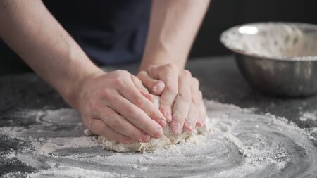 man working with dough on concrete countertopの写真素材