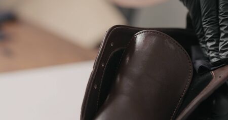 man hands in black gloves applying protective cream to brown leather chukka boots, wide photoの写真素材