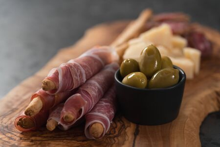 Italian snacks on olive wood board, shallow focusの写真素材