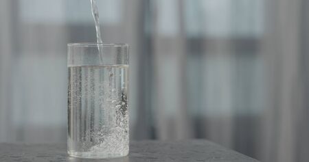 pour soda into glass on concrete surface