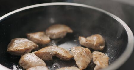 shot of chicken fillet slices frying on non-stick pan, wide photoの写真素材