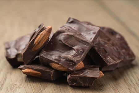 homemade dark chocolate with almonds on oak wood surface, shallow focusの写真素材