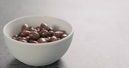 chocolate covered pistachio in white bowl with copy spaceの写真素材