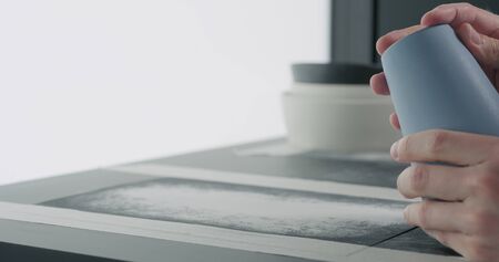 man hands check bottom of blue ceramic glass, wide photo