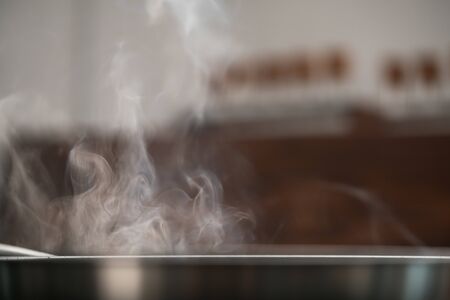 Steam rising from fry pan while cooking foodの写真素材